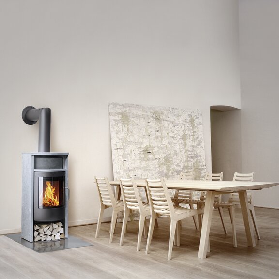 Kaminofen BANDO mit Specksteinverkleidung in minimalistisch eingerichtetem Wohnbereich