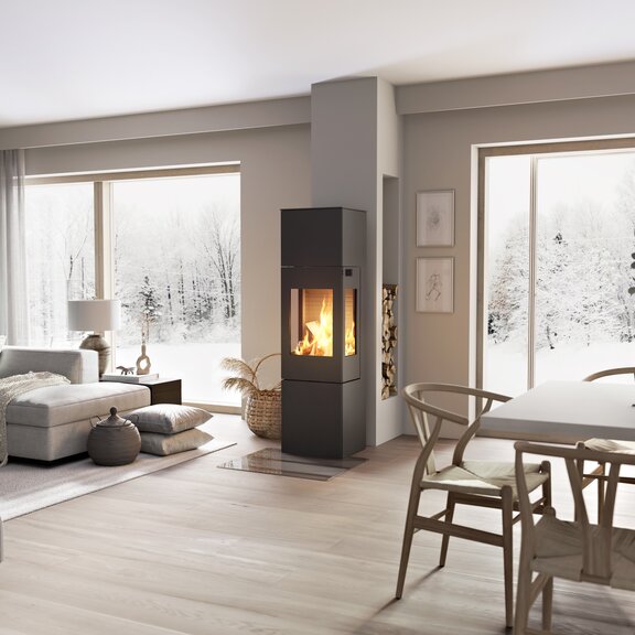 Holz-Kaminofen NEXO 160 in Schwarz mit Stahltür und Seitenfenster mitten im Wohnraum zwischen Esszimmer und Wohnzimmer