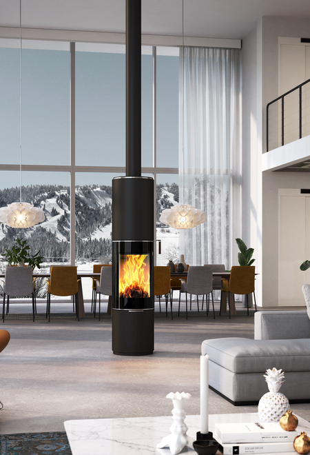 Holz-Kaminofen PILAR in Schwarz mit Vollglas-Feuerraumtür als drehbarer, runder Kaminofen mitten in einem riesigen Wohnraum
