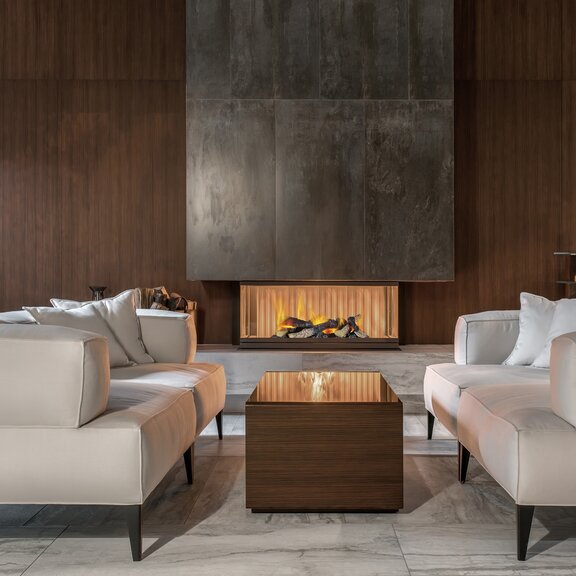 Elektrofeuer Cassette 400 LED mit Holz-Aufsatz verbaut in ein Betonelement im chicen Wohnzimmer