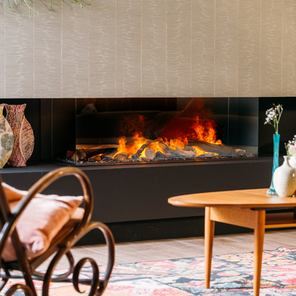 Elektrokamin e-Matrix Linear 1300/400 dreiseitig im Wohnzimmer mit Teppich und Schaukelstuhl