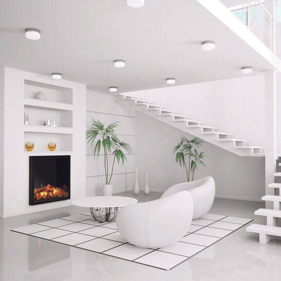 Elektrofeuer Juneau im weissen Wohnzimmer mit Treppe und weissen Möbeln