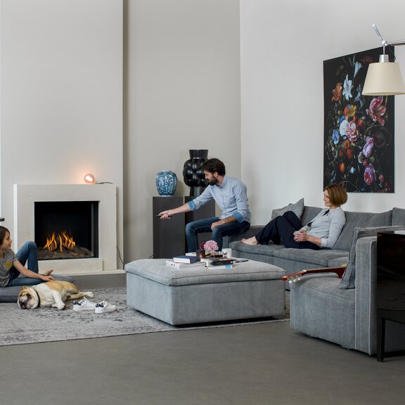 Mann bedient den Gas-Kamin MatriX 800/650 Front von Faber mit einer Fernbedienung