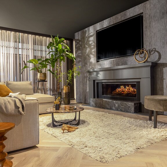 Das Elektrofeuer E-One 130 Front eingebaut an der schwarzen Wand im gemütlichen Wohnzimmer im hygge Style.