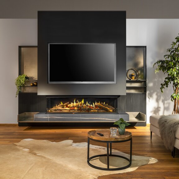 Dreiseitiger Elektrokamin E-One 160 S im modernen Wohnzimmer mit Sofa und Teppich.