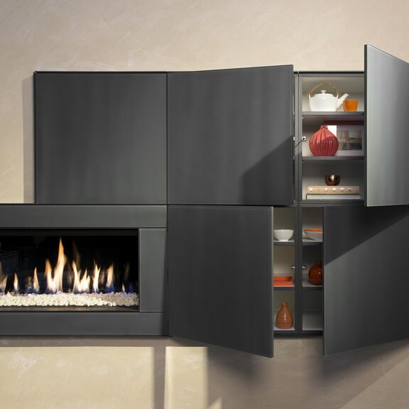 Gas-Kamin G100/41F von Kalfire mit weissen Steinen im Feuerraum integriert in einem praktischen Möbel mit Stauraum