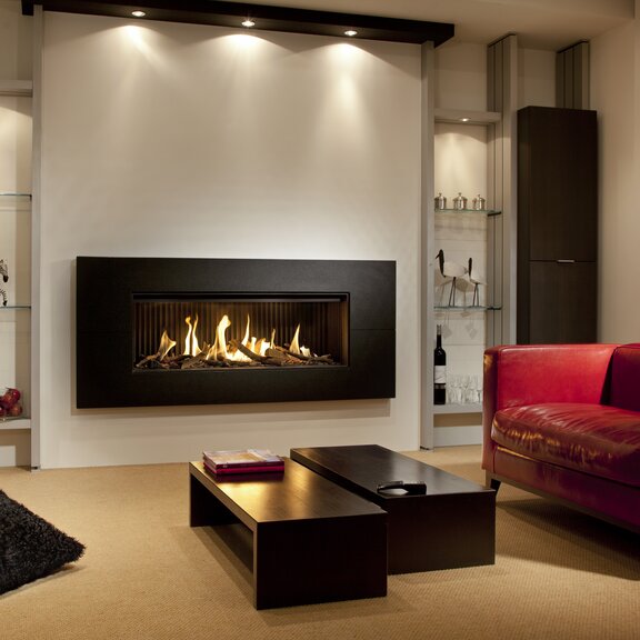 Gas-Kamin G120/41F mit dunkler Umrahmung an weisser Wand eingebaut im Wohnzimmer