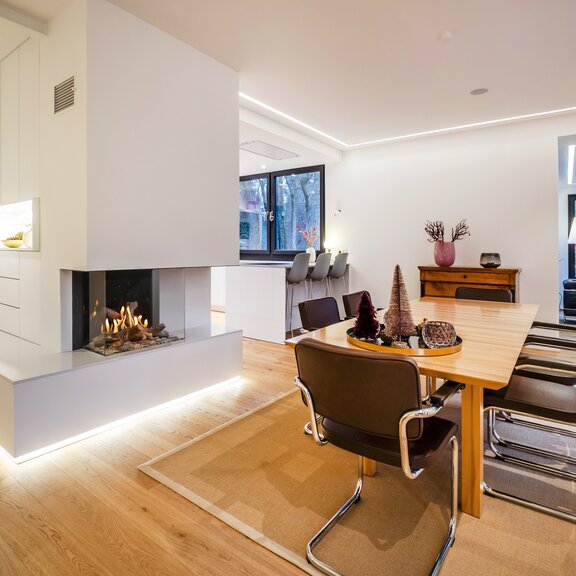 Gas-Kamin GP70/55S dreiseitig verglast in weisse Wand eingebaut im Esszimmer mit Parkett Boden