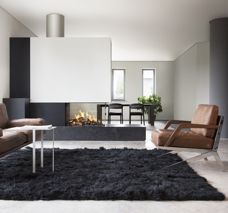 Gas-Kamin GP85/50R Raumteiler im schlichten Wohnzimmermit hellen Wänden und schwarzem Teppich