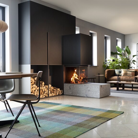 Holz-Kamin W53/50R Raumteiler von Kalfire als dreiseitiger Kamin, der Wohnzimmer und Esszimmer stillvoll voneinander trennt