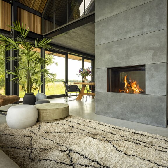 Holz-Kamin W80/52T von Kalfire als Zentrum im Haus zwischen Küche und Wohnraum mit natürlicher Einrichtung